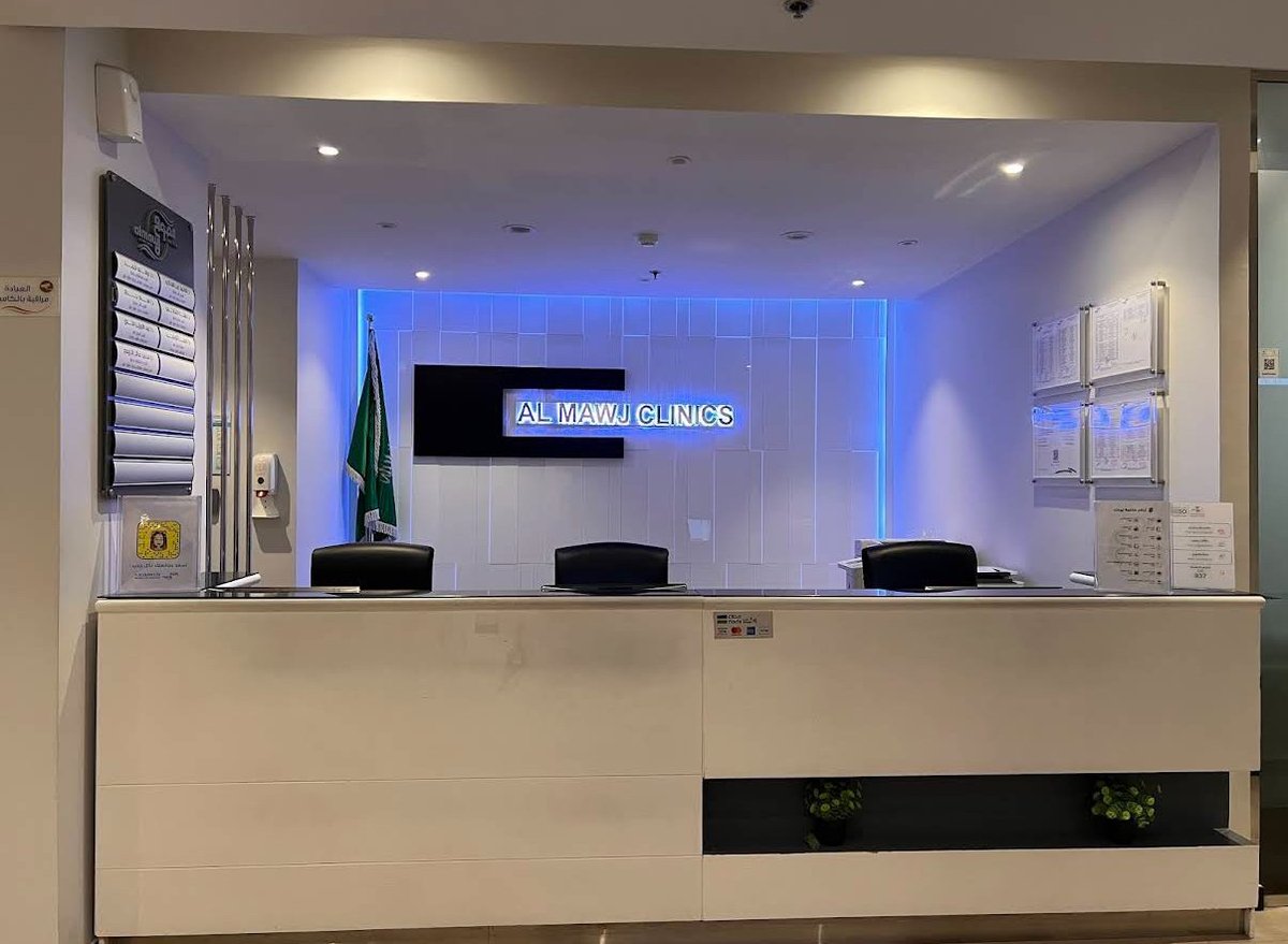 Modern office reception desk with blue LED lighting, neon sign, and Brazilian flag in background